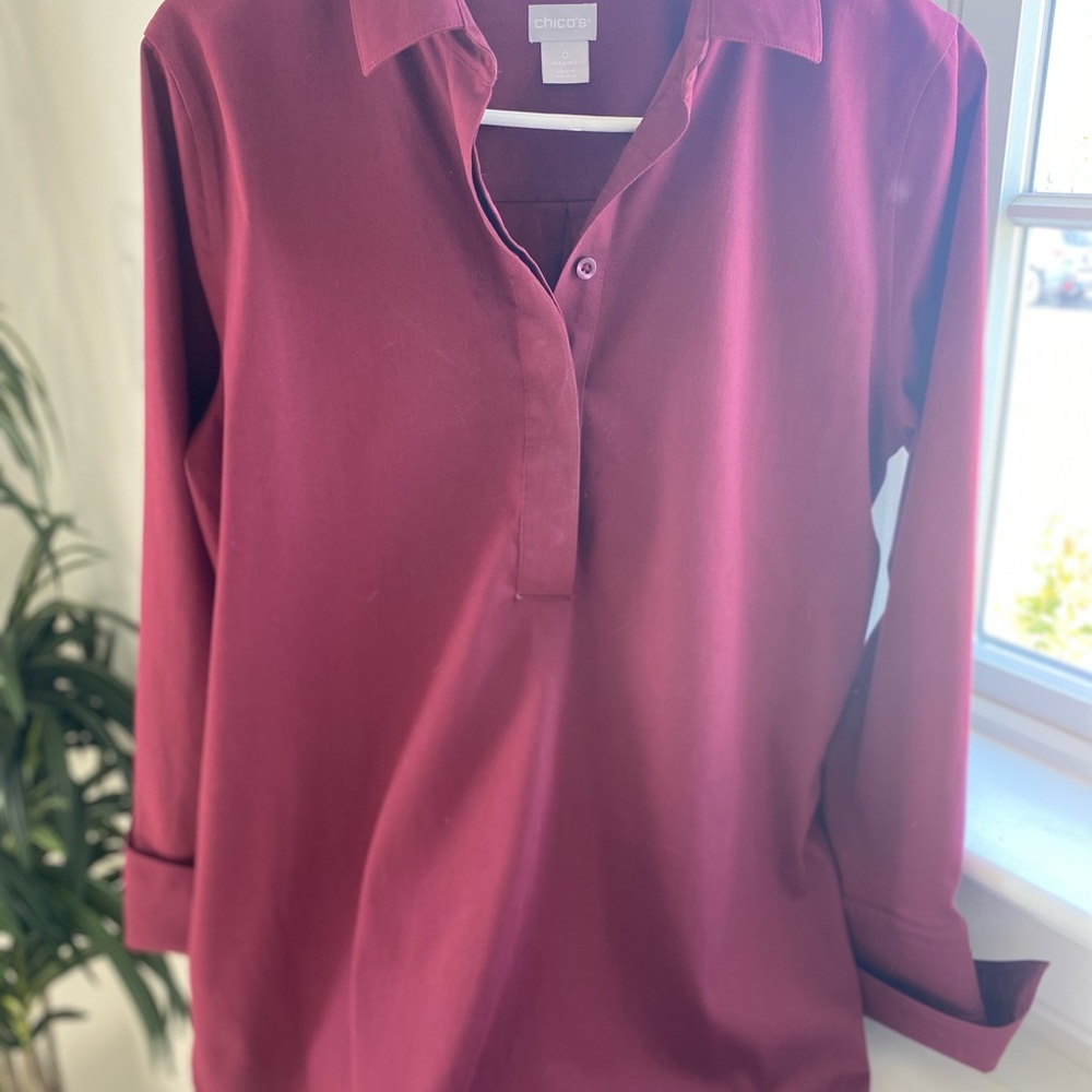 Burgundy blouse with shirt tail side slits.